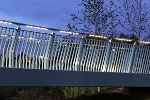 LED luminaires inset into hand rails which project light uniformly onto the walkway